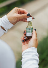 Person holding CBD tincture bottle - view 2